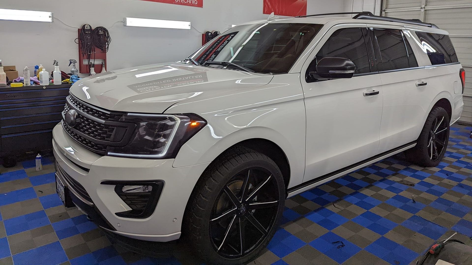 A white ford expedition is parked in a garage.