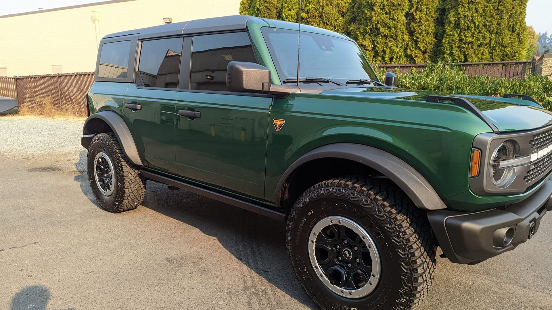A green ford bronco is parked in a parking lot.