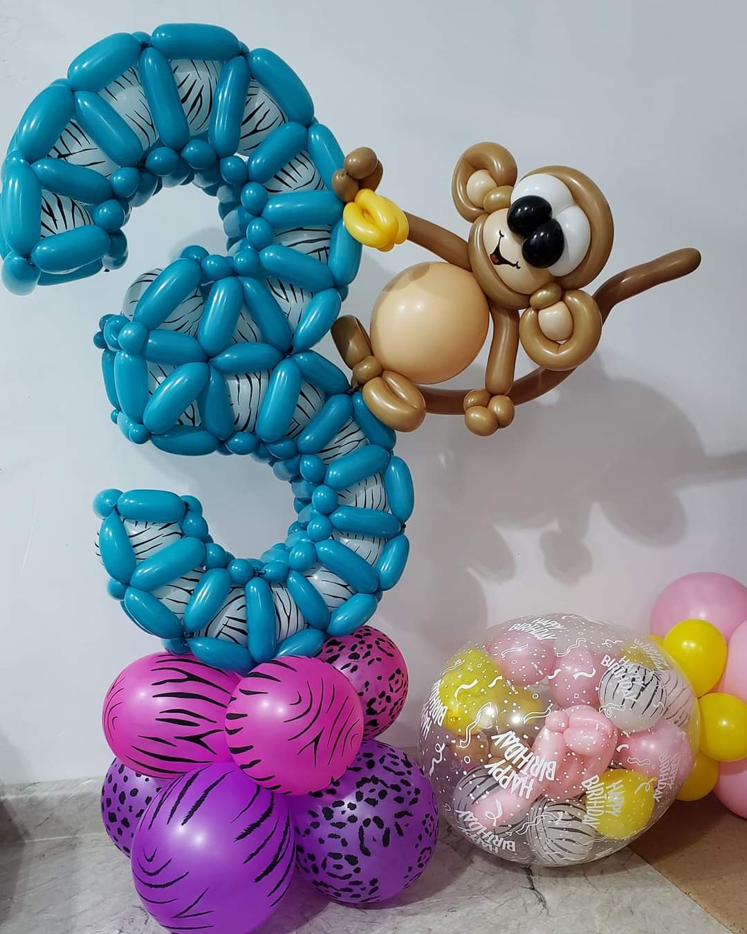 Birthday celebration balloon marquee. Custom 3 foil with twisted blue frame and custom brown monkey holding bananas. 