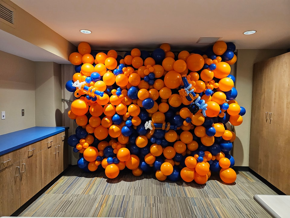 Neon orange and dark blue organic balloon wall. 