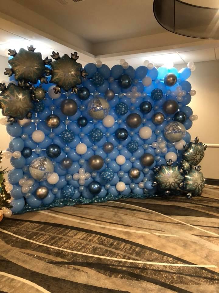 Snowflake wall for corporate event. Assortment of foil snowflake and latex balloons. 