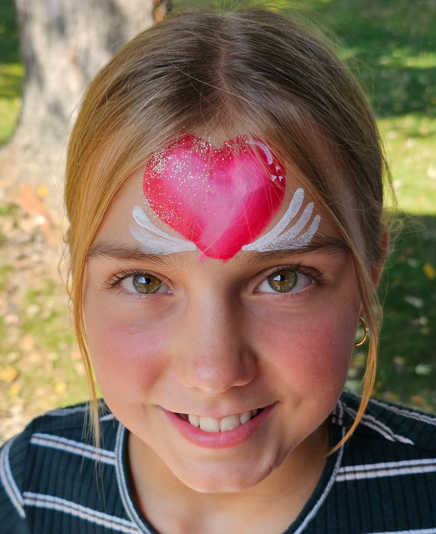 Pink heart, white wings and glitter face paint