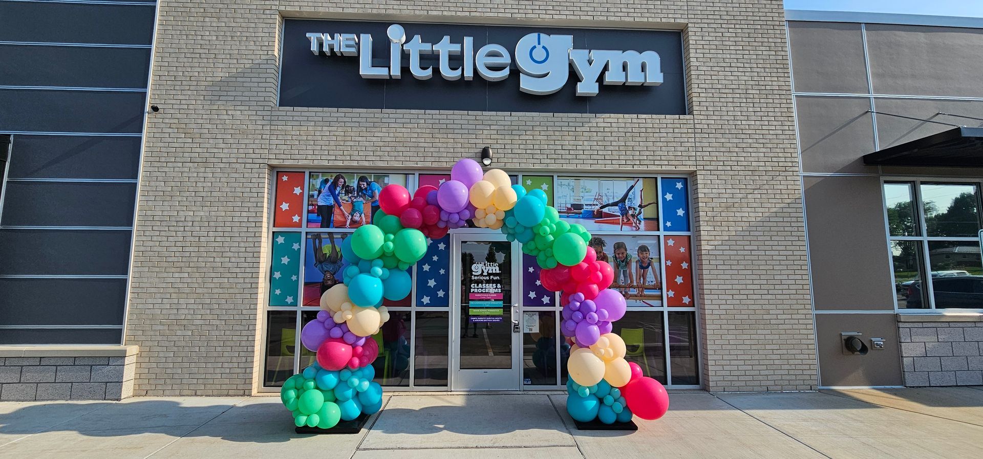 Organic full arch for grand opening. A mix of colors, beige, pink, teal, green, light purple. 