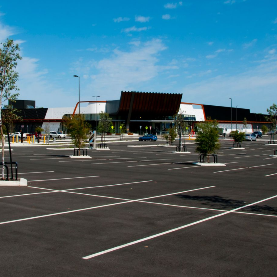 Empty black asphalt parking lot with white painted lines and spaces