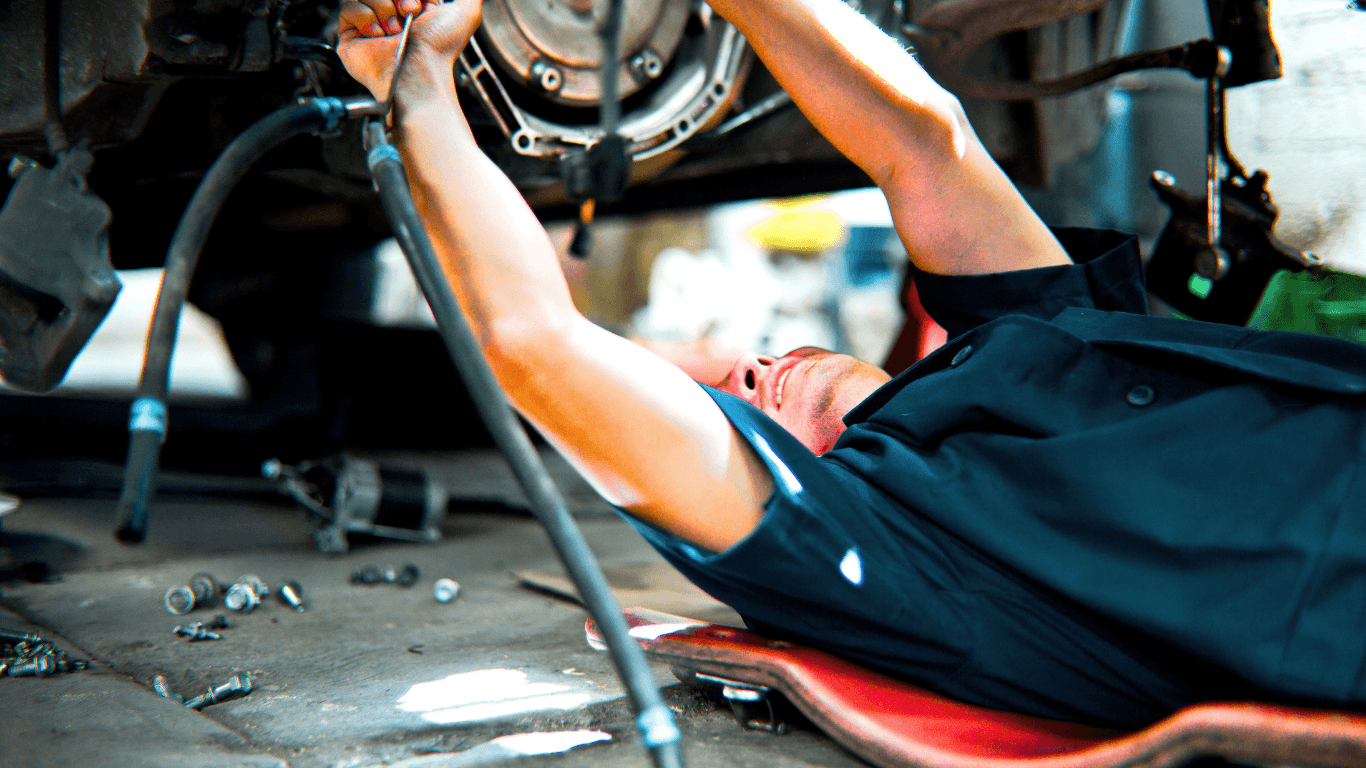 a mechanic on his back doing a vehicle service