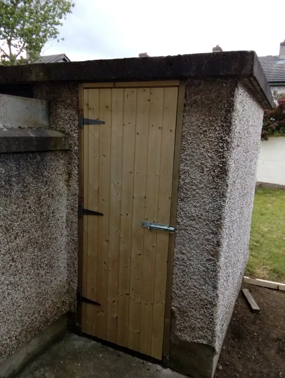 A small concrete building with a wooden door
