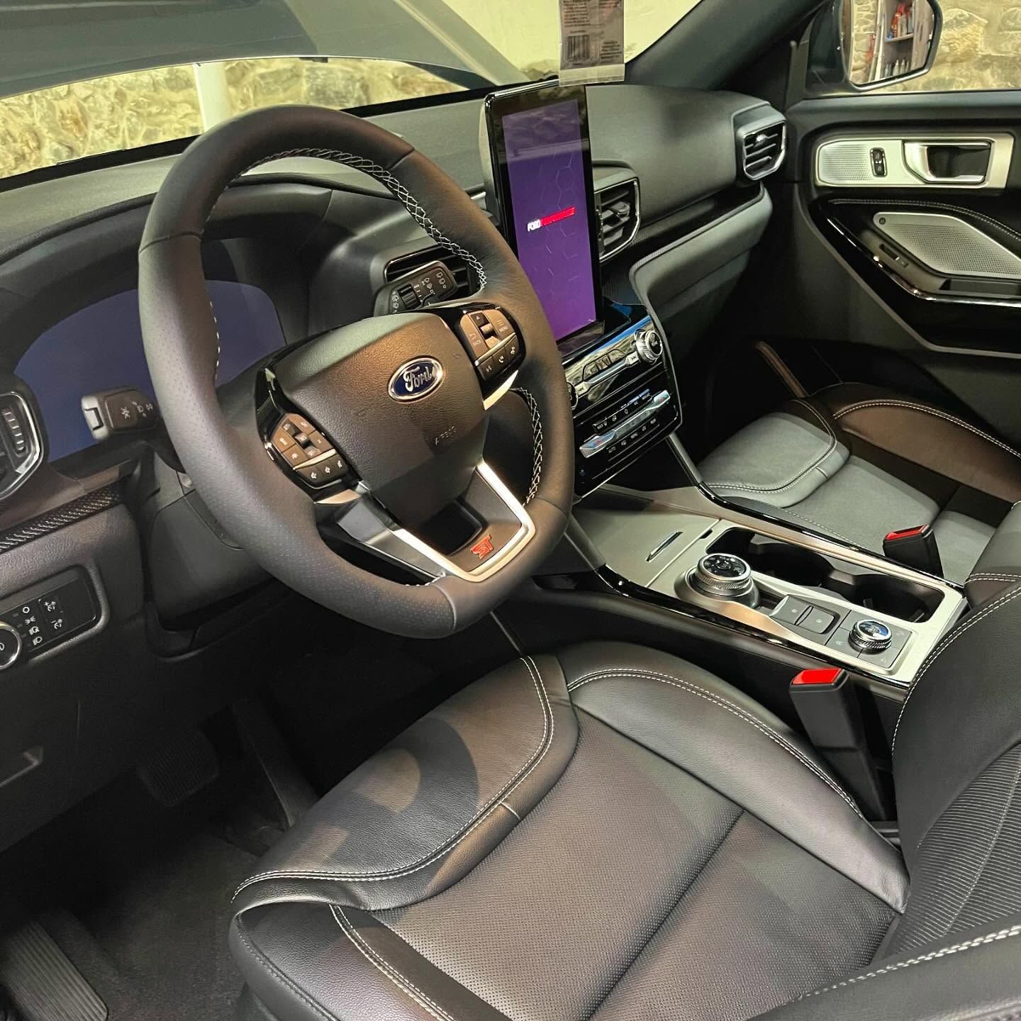 The interior of a ford explorer with a tablet on the dashboard.