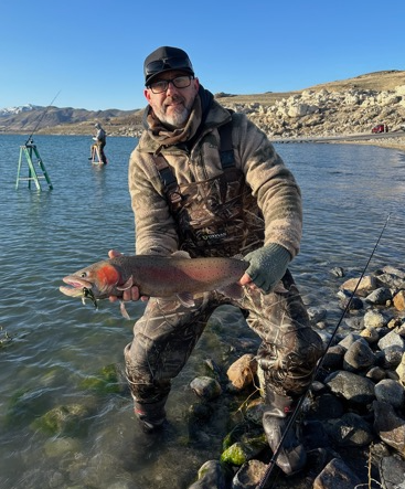 zach holding a fish in a river