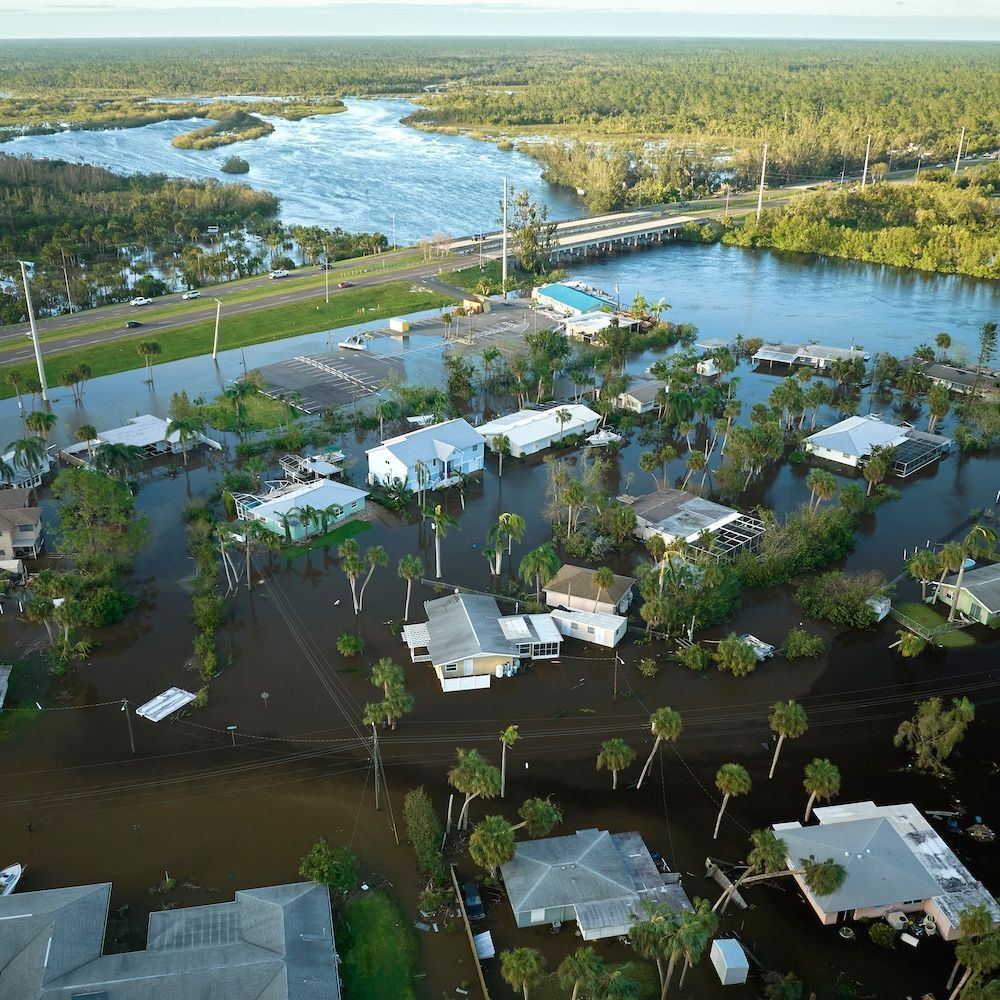 An aerial view of a flooded area with houses and trees