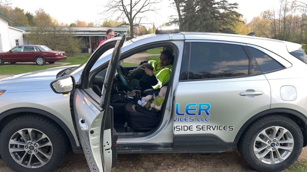 A man is sitting in the driver 's seat of a car.