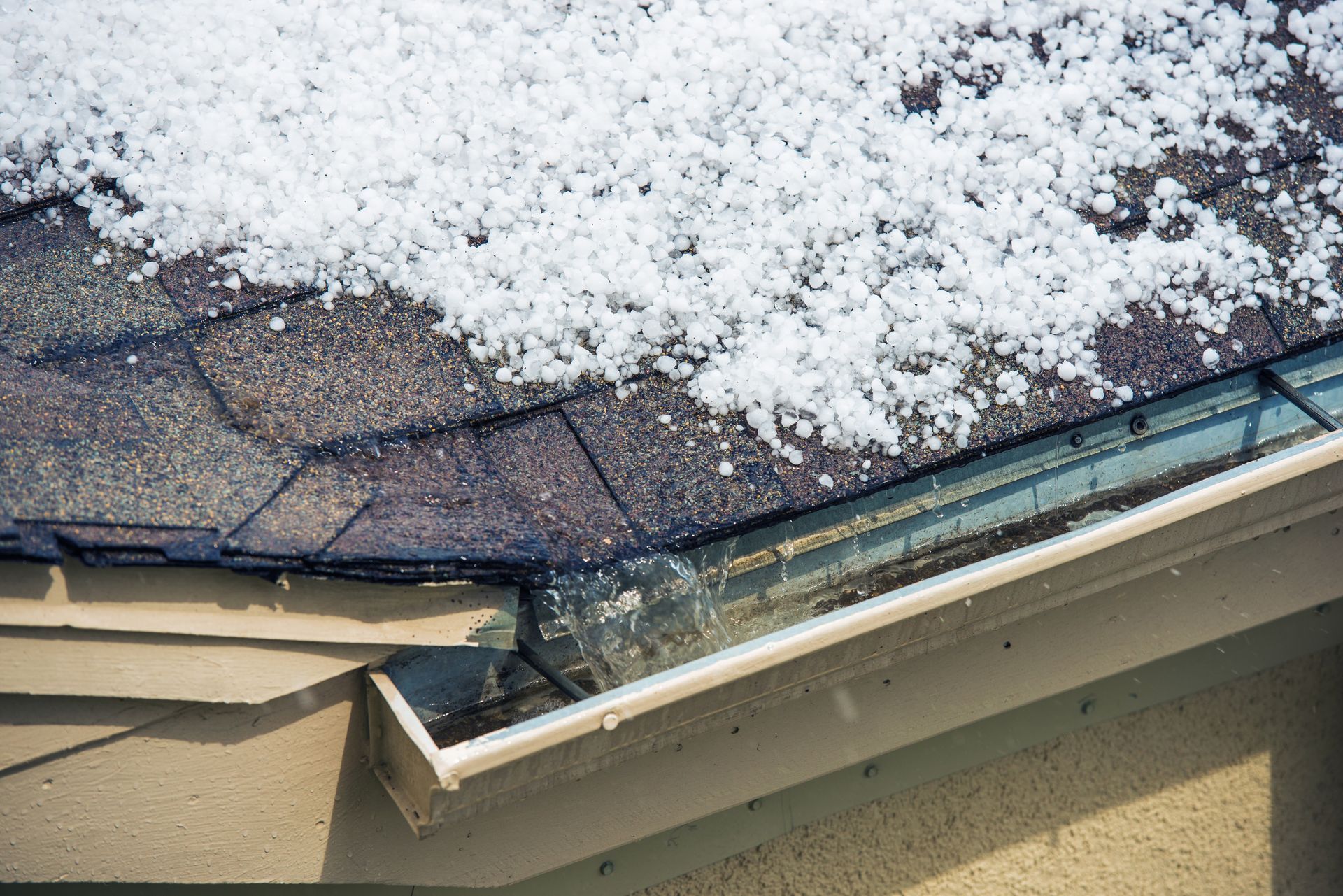 Snow-covered roof with damaged gutter and ice buildup at the eaves