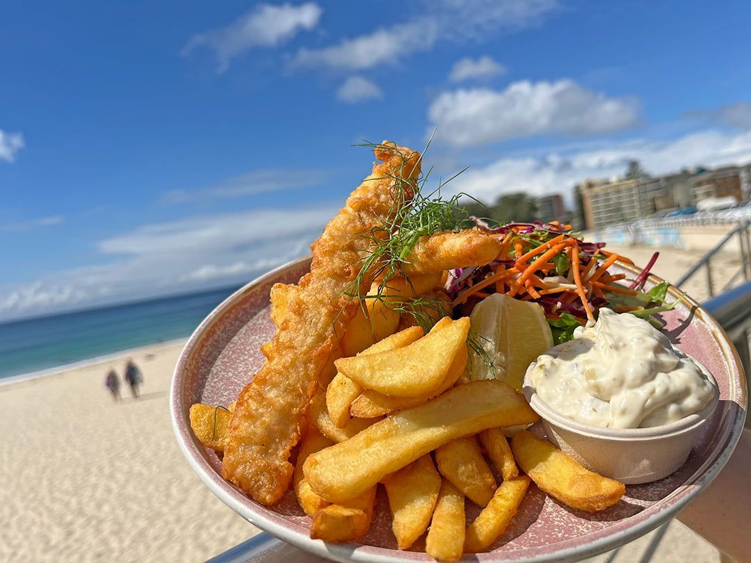 A Plate Of Fish And Chips With A Salad On A Table — Beach Bums Cafe In Forster, NSW