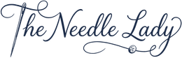“The Needle Lady” in elegant blue script with a needle and thread decorative flourish
