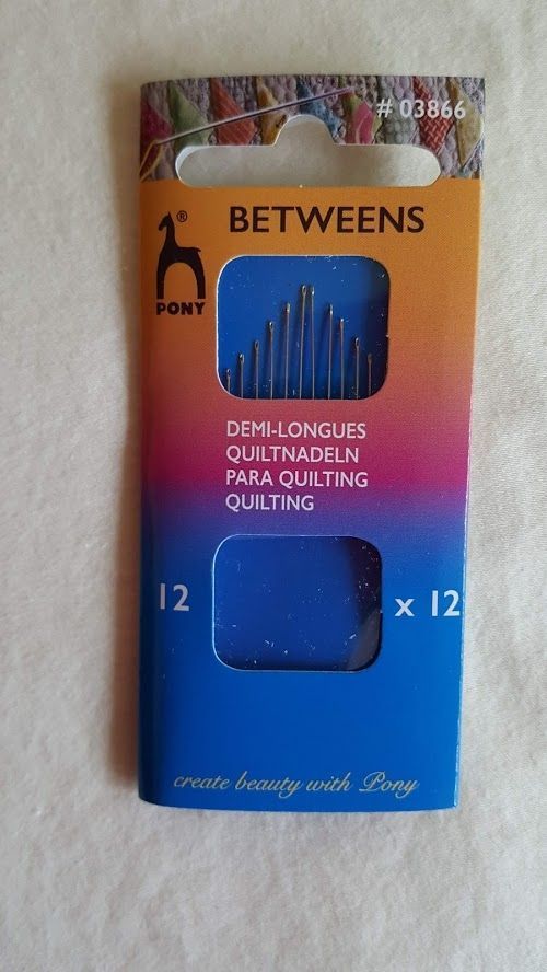 Orange-and-blue package of textile quilting needles labeled “BETWEENS,” with two clear windows and 12-count marking