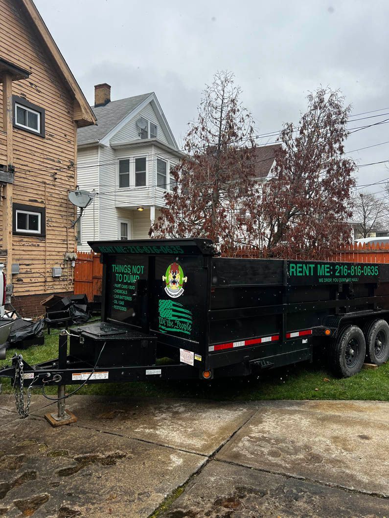 A dump truck is parked in a driveway next to a house.