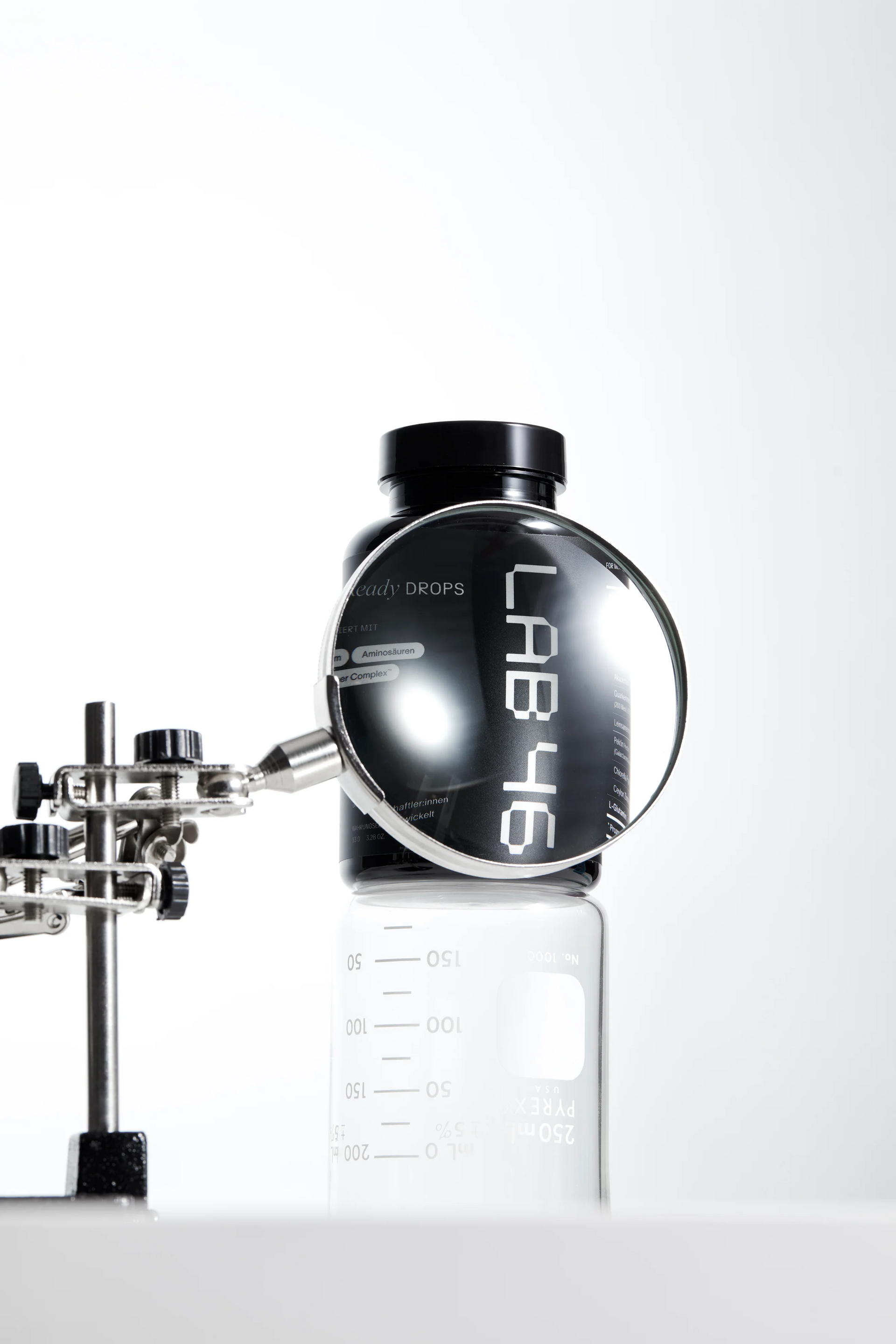 Schwarze ABUS-Flasche auf einem Metallklemmenständer vor weissem Hintergrund