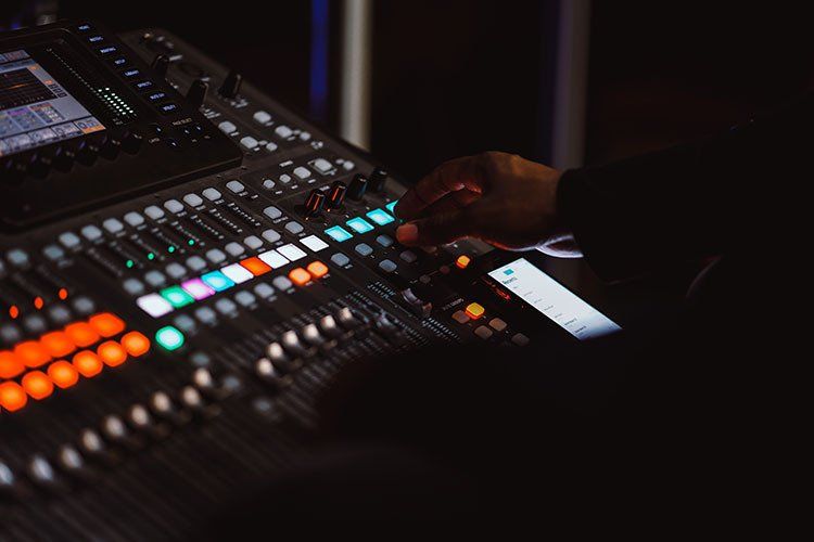 A person is using a mixer in a dark room.