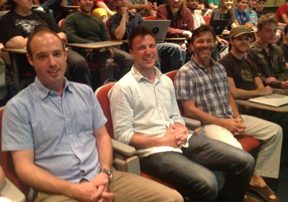 A group of men are sitting in a lecture hall