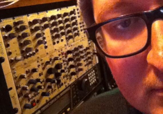 Jakob Thiesen with glasses next to audio mixing equipment; close-up.