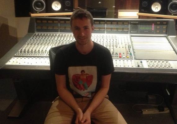 Luke Schindler in a black shirt sits in front of a mixer
