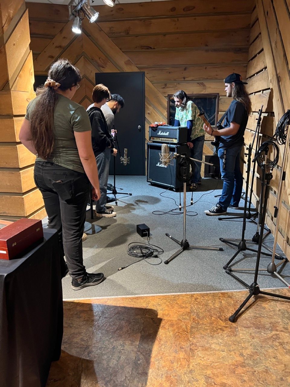 A group of people are standing in a room playing instruments.