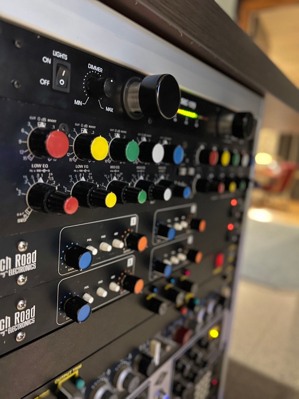 A rack of black audio equipment with colorful knobs. The settings and dials are visible.