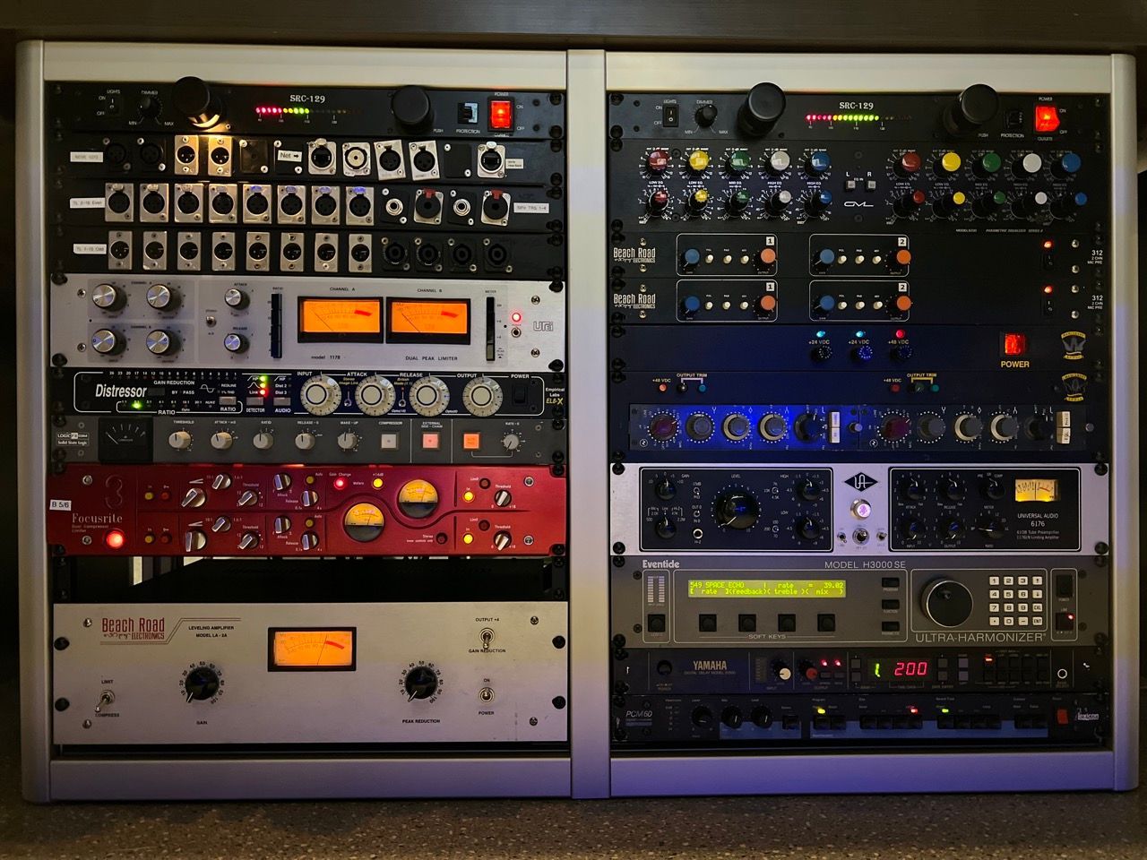 Two silver rack cases filled with professional audio recording equipment, with various knobs, buttons, and displays.