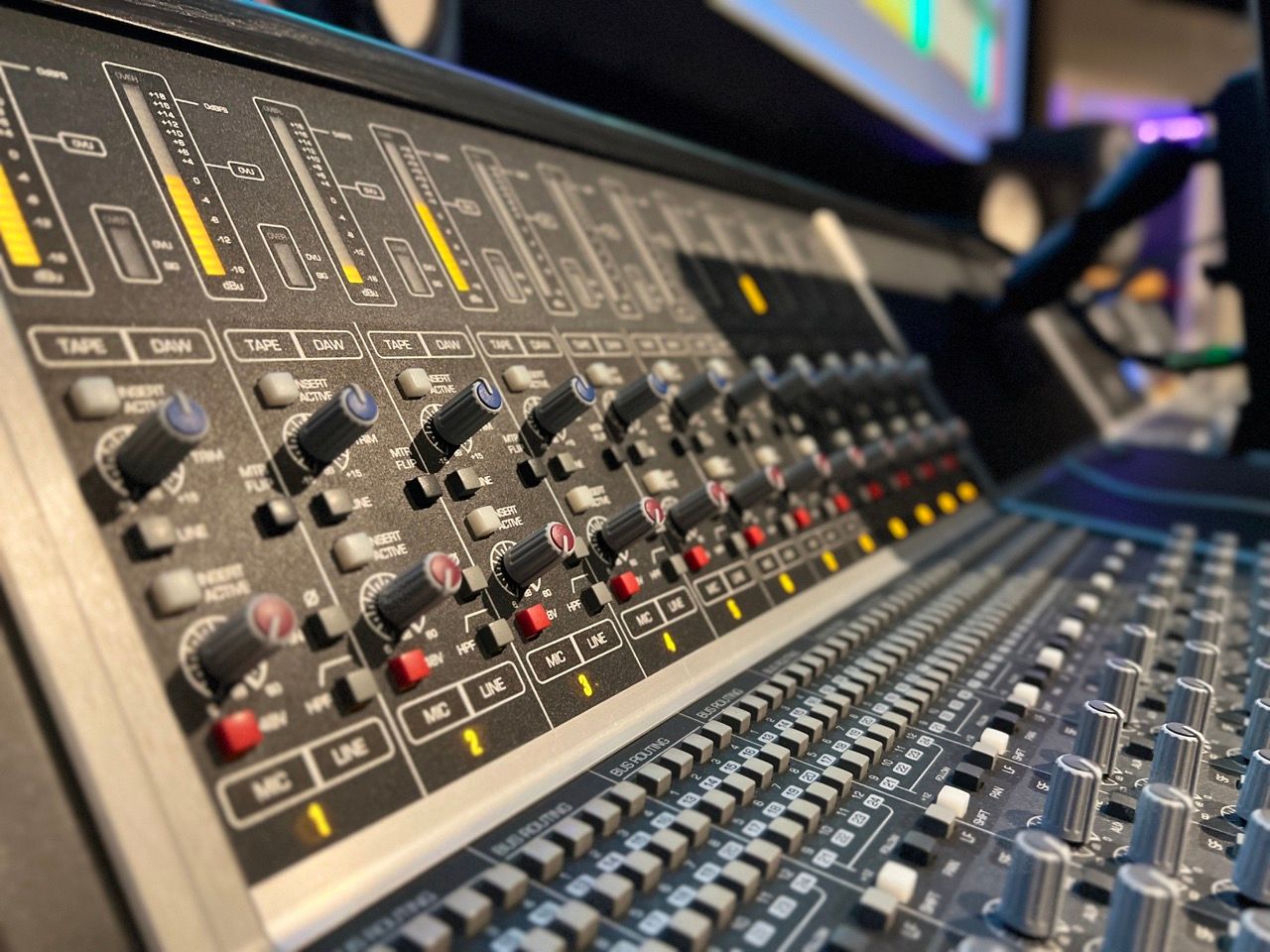 A close up of a mixer with a lot of knobs and buttons