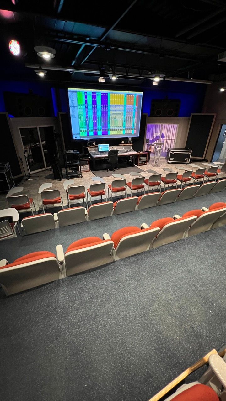 A large auditorium with rows of seats and a large screen.