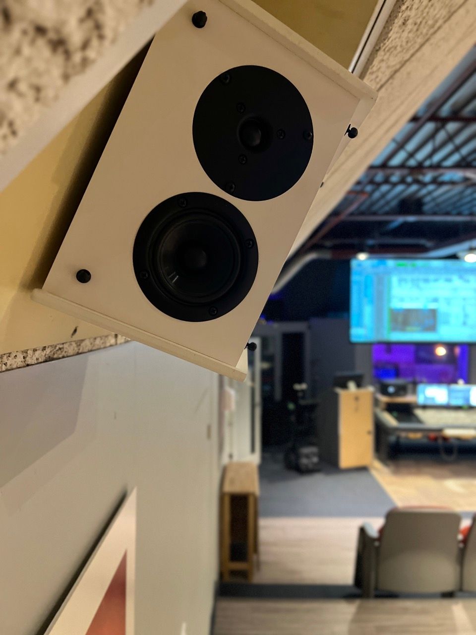 A pair of speakers mounted on a wall in a room