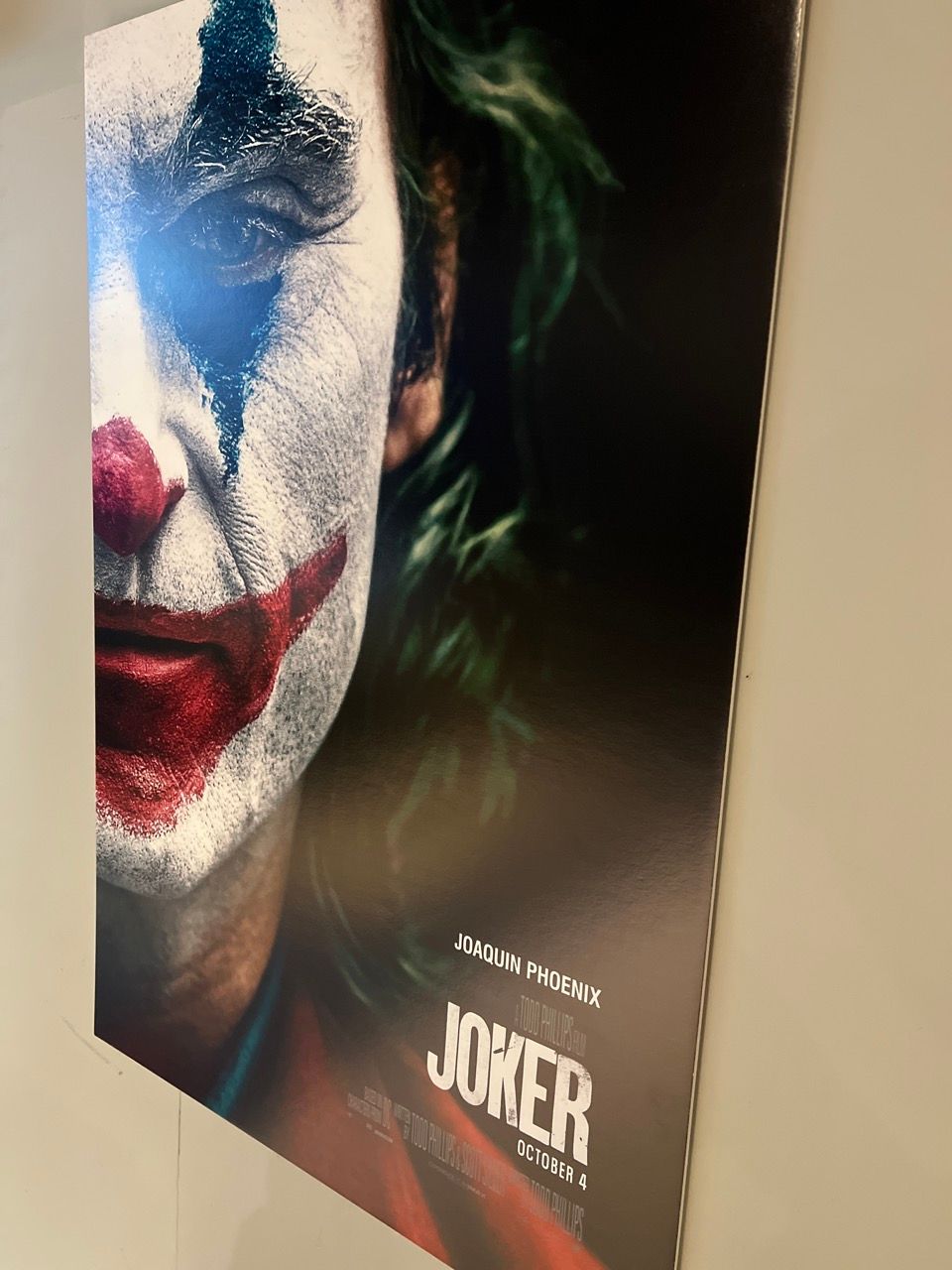 A poster for the movie joker is hanging on a wall