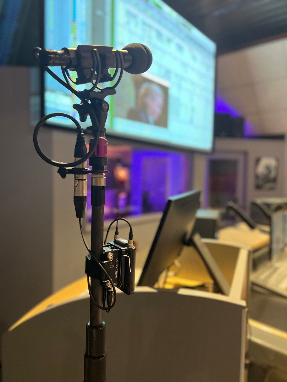 A microphone is sitting on a stand in front of a projector screen