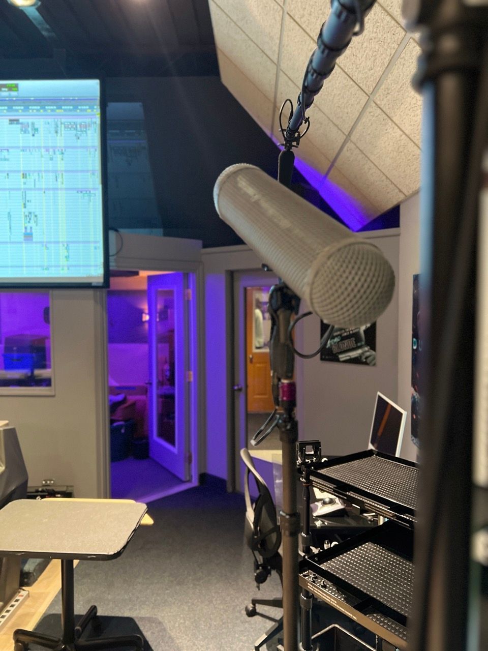 A microphone is hanging from a pole in a recording studio