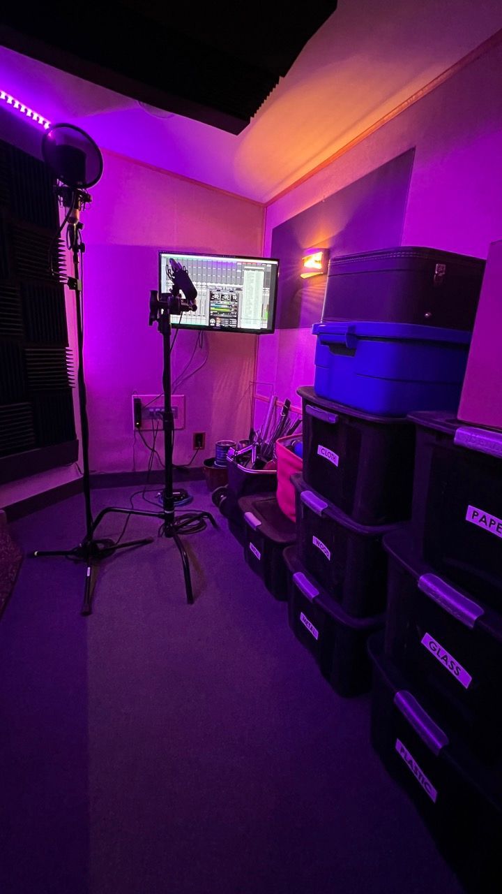 A room with a lot of boxes and a tv on the wall.