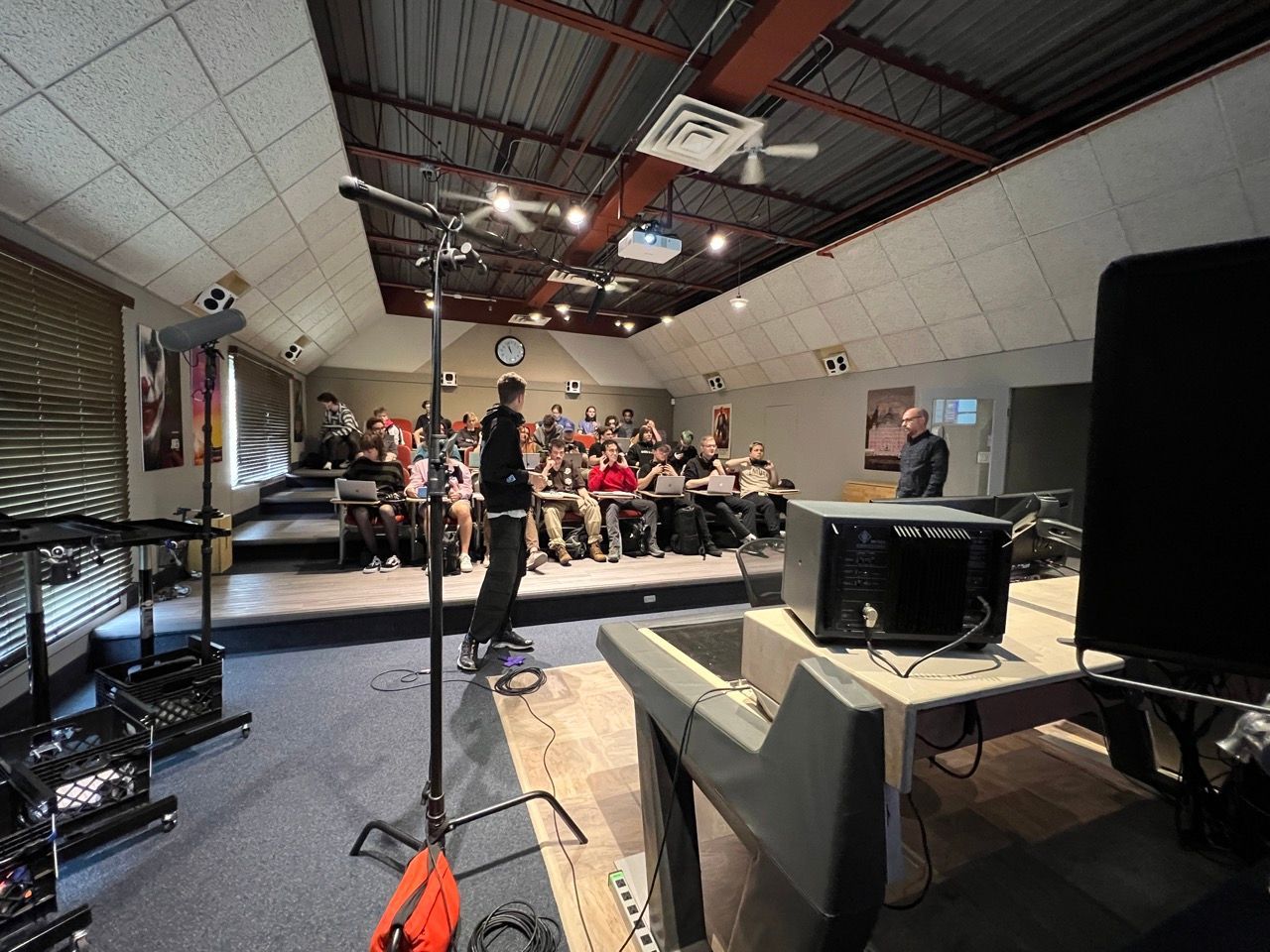 A group of people are sitting in a room with a projector on a table.