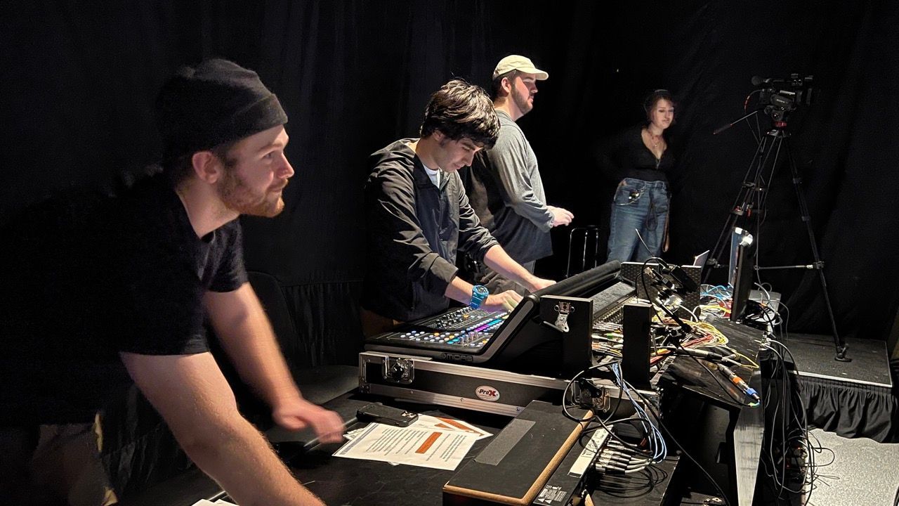 A group of people are standing around a table in a dark room.