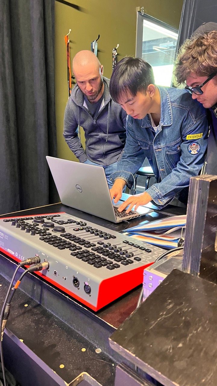 A group of men are looking at a laptop computer.