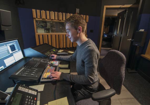 Devin Hoare is sitting at a desk in front of a computer.