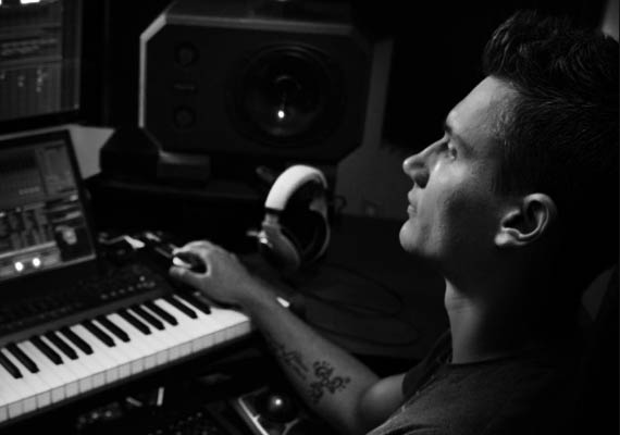 Dmitri Belichenko with a tattoo on his arm is playing a keyboard
