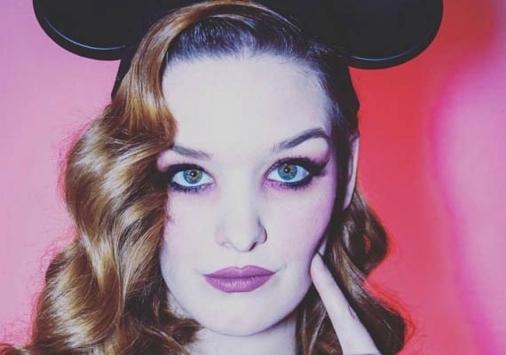 Close up of a Kelly Burrow wearing a mickey mouse headband and a Music Supervisor.