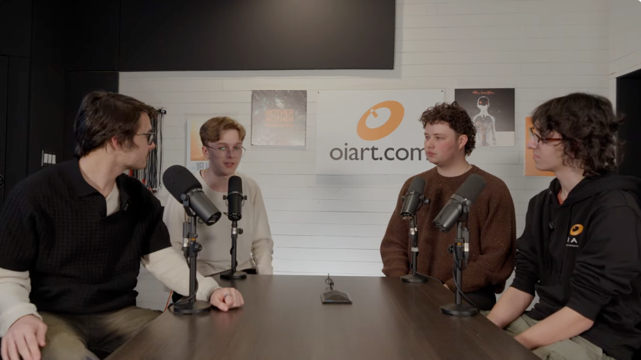 Four people seated around a conference table with microphones in a podcast studio