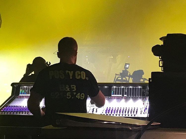 A man wearing a black shirt that says posty co.