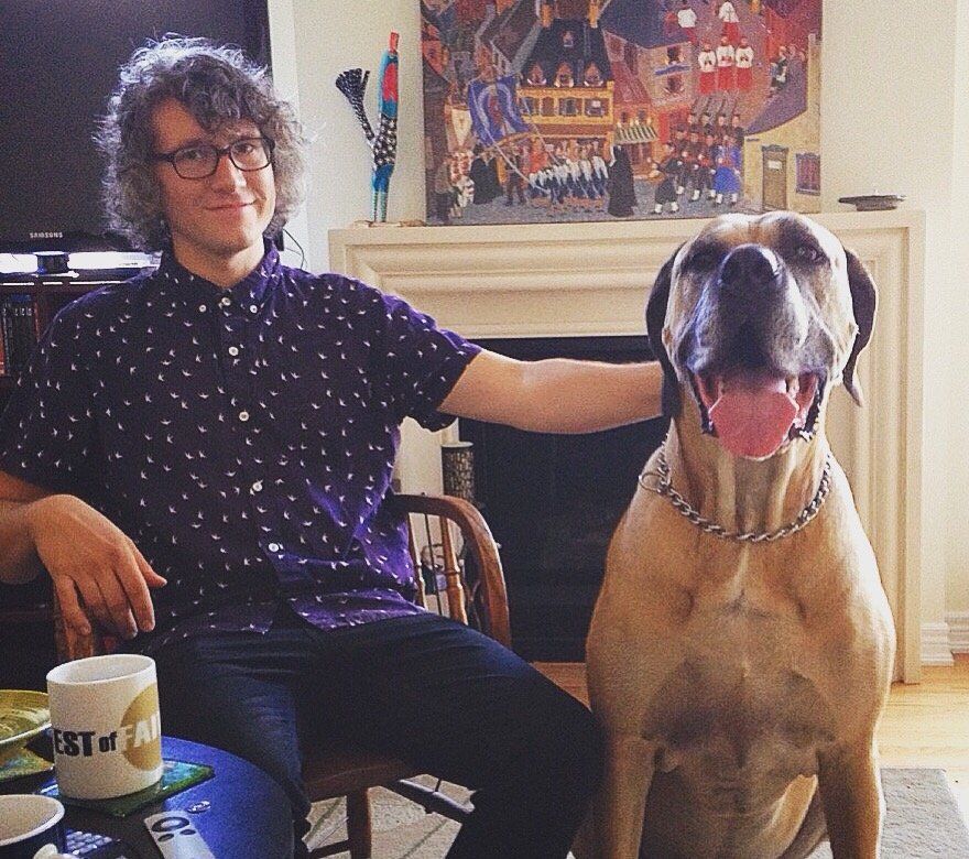 Joel Waddell sitting next to a dog with a mug that says