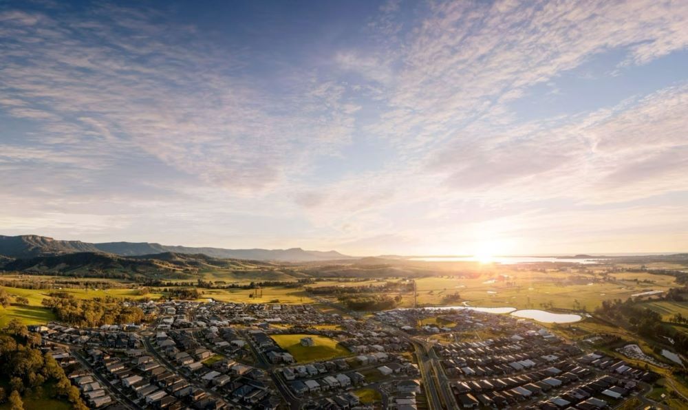 An Aerial View of A City at Sunset with The Sun Shining Through the Clouds — Evolution Building Group Dapto, NSW