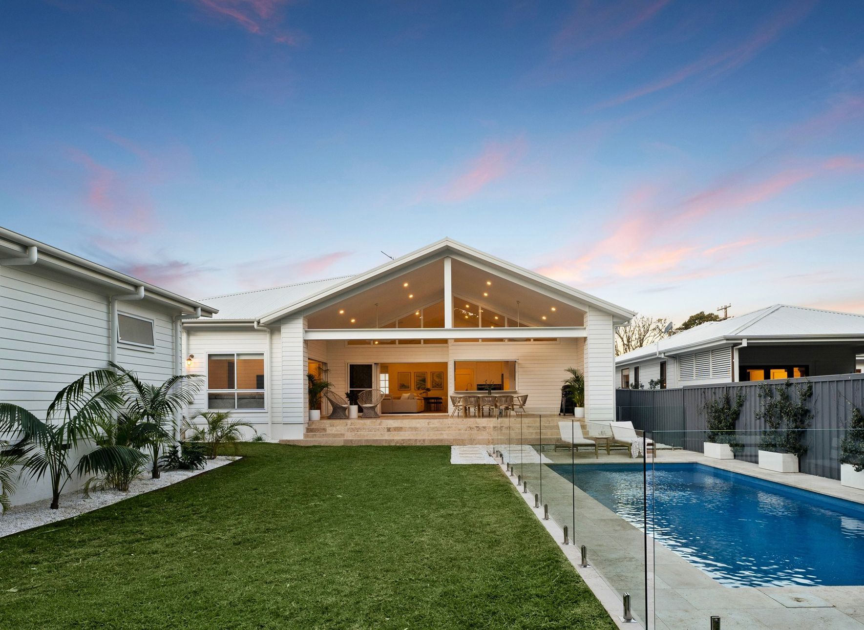 Backyard View of a White House With a Pool, Lawn — Evolution Building Group in Wollongong, NSW