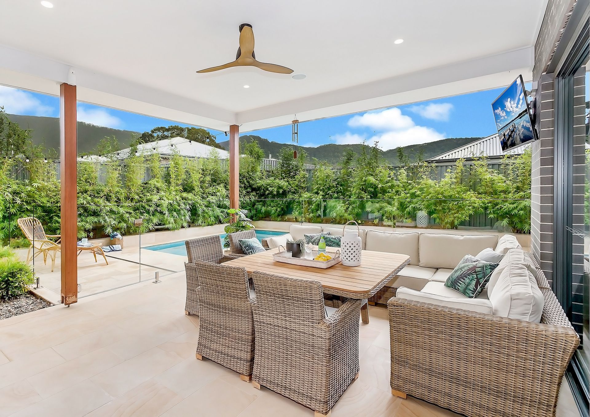 Covered Patio With Wicker Seating, Pool, and Lush Backyard Greenery — Evolution Building Group in Dapto, NSW