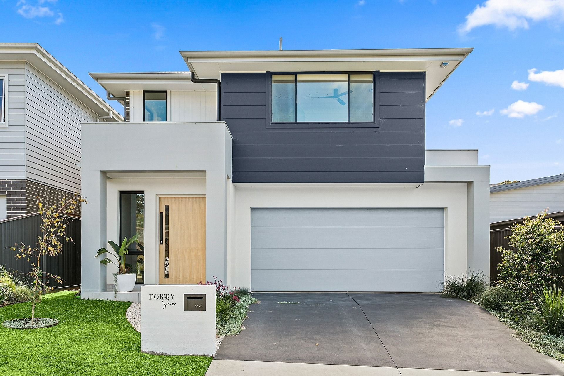 The Front of a Modern House With a White Garage Door — Evolution Building Group Dapto, NSW
