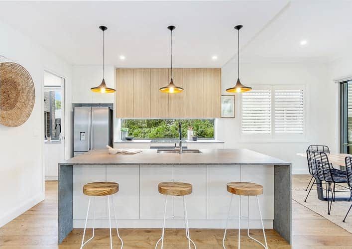 A Kitchen with A Large Island, Stools and A Refrigerator — Evolution Building Group Dapto, NSW