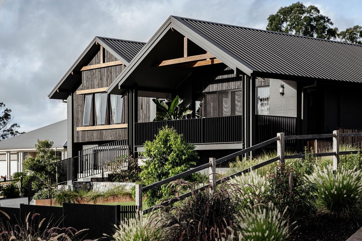 Modern Black-and-wood House With Large Gabled Roof on a Hillside — Evolution Building Group in Dapto, NSW