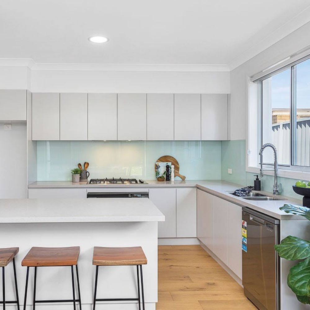 A Kitchen with White Cabinets, a Stove, a Sink, and A Window — Evolution Building Group Dapto, NSW